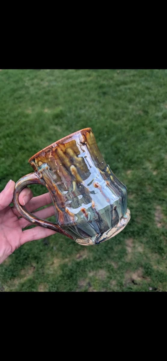 A faceted amber and teal mug thrown on the wheel